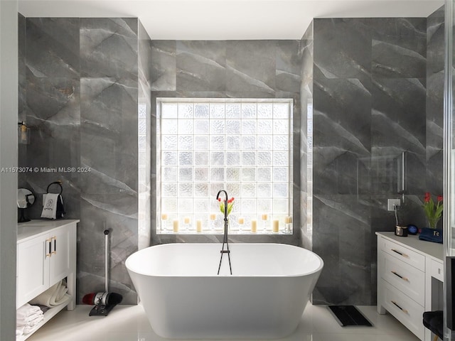 bathroom featuring vanity, tile floors, tile walls, and a tub