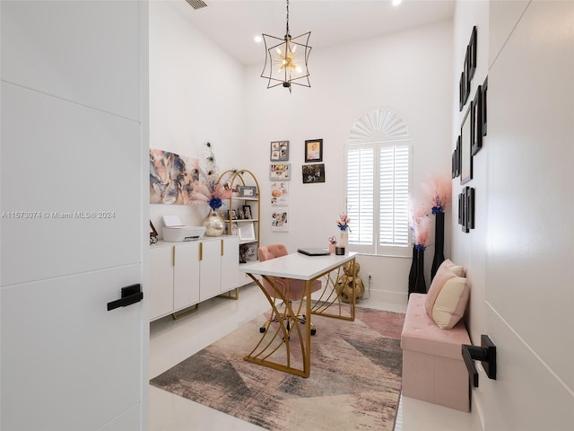 office featuring a towering ceiling and an inviting chandelier