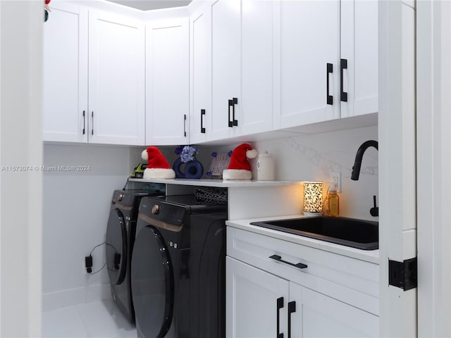 laundry room featuring washing machine and dryer, cabinets, sink, and tile flooring