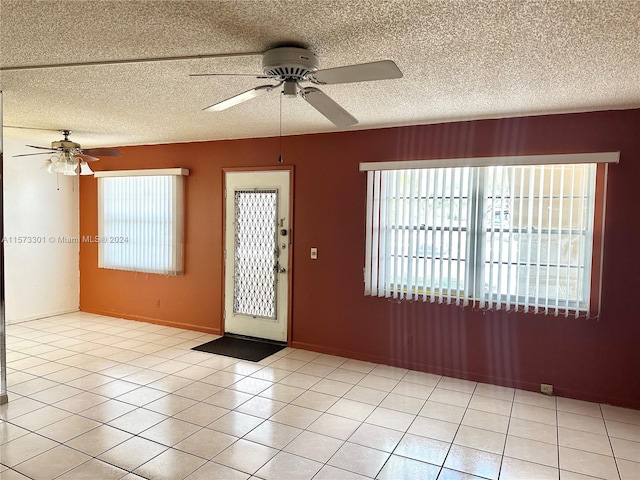 tiled foyer entrance featuring a textured ceiling and ceiling fan