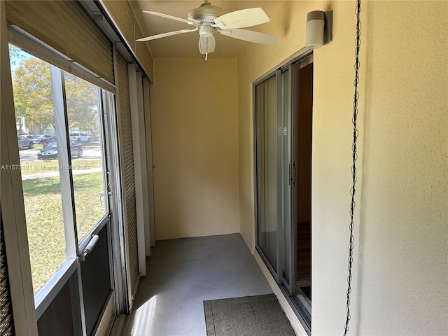 unfurnished sunroom featuring ceiling fan