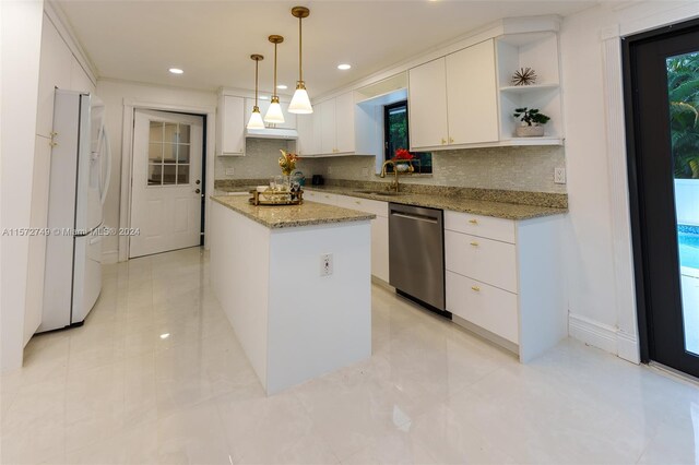 kitchen featuring hanging light fixtures, a kitchen island, white cabinetry, stainless steel dishwasher, and sink