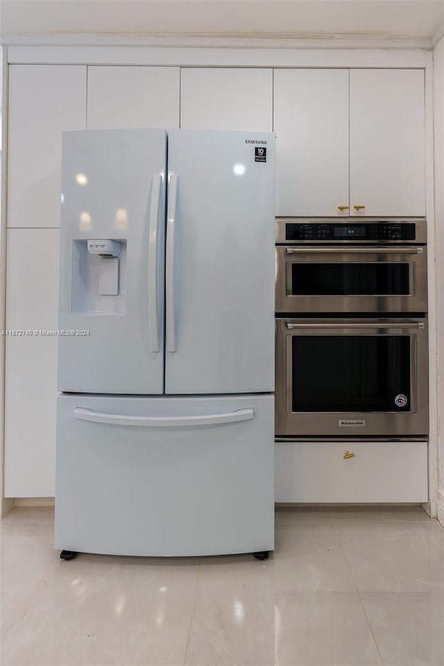 kitchen featuring white cabinetry, double oven, and refrigerator with ice dispenser