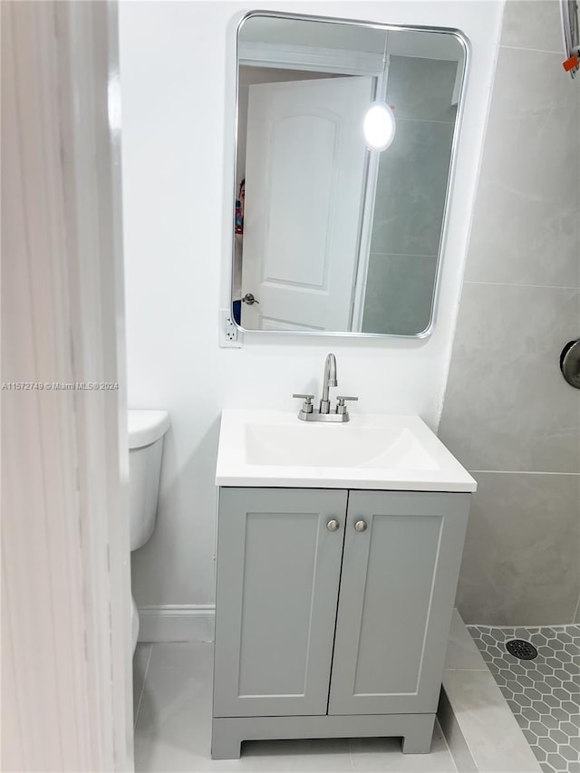 bathroom featuring toilet, vanity, and tile patterned flooring