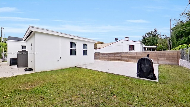 rear view of property featuring a yard and a patio area