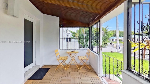 unfurnished sunroom with wooden ceiling and vaulted ceiling