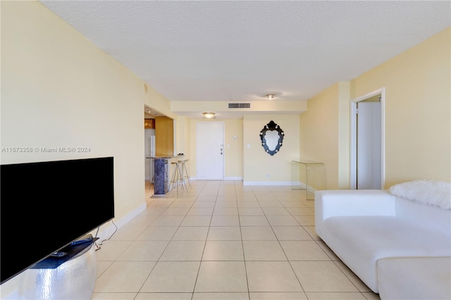 tiled living room featuring a textured ceiling