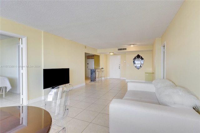 living room featuring a textured ceiling and light tile patterned floors