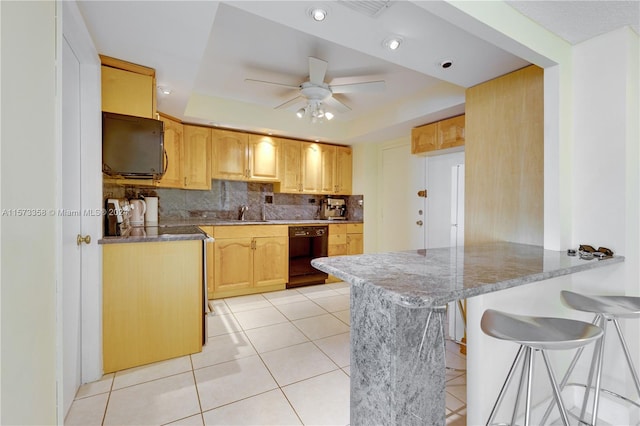 kitchen with kitchen peninsula, tasteful backsplash, ceiling fan, dark stone countertops, and black appliances