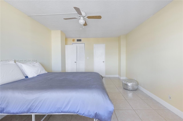 tiled bedroom featuring a textured ceiling and ceiling fan