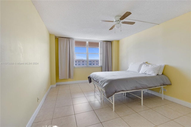 tiled bedroom featuring a textured ceiling and ceiling fan