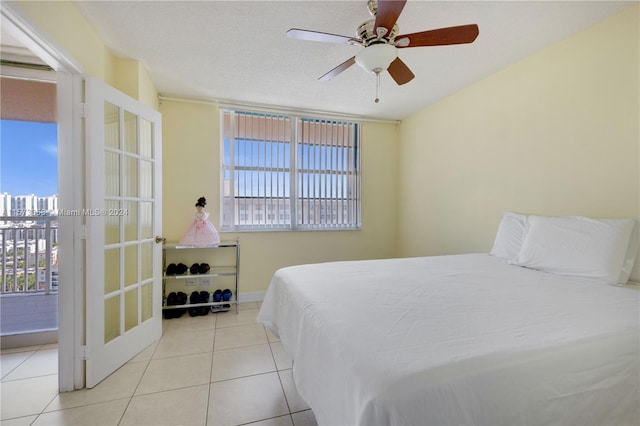 tiled bedroom featuring ceiling fan and a textured ceiling