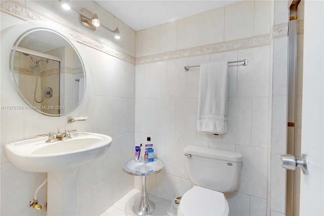 bathroom featuring toilet and tile walls