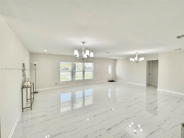 spare room with a notable chandelier