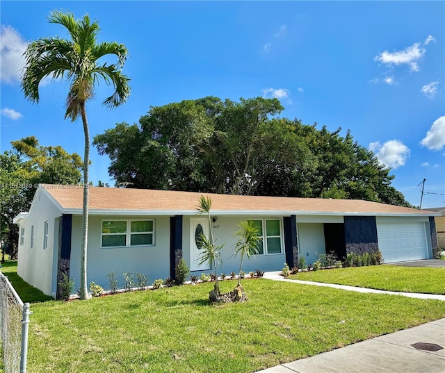 ranch-style home with a garage and a front lawn