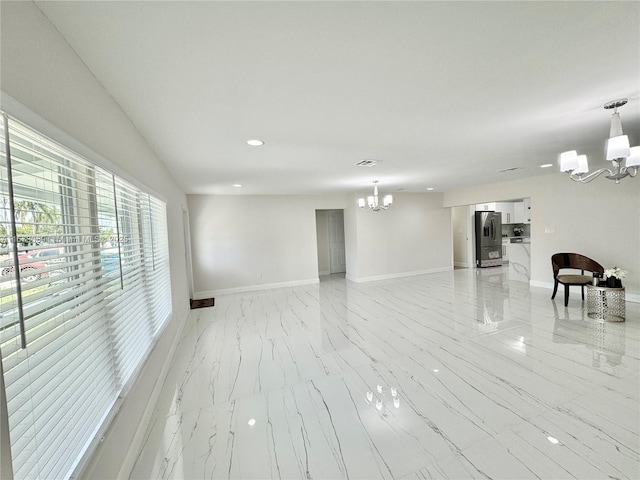 unfurnished room featuring an inviting chandelier