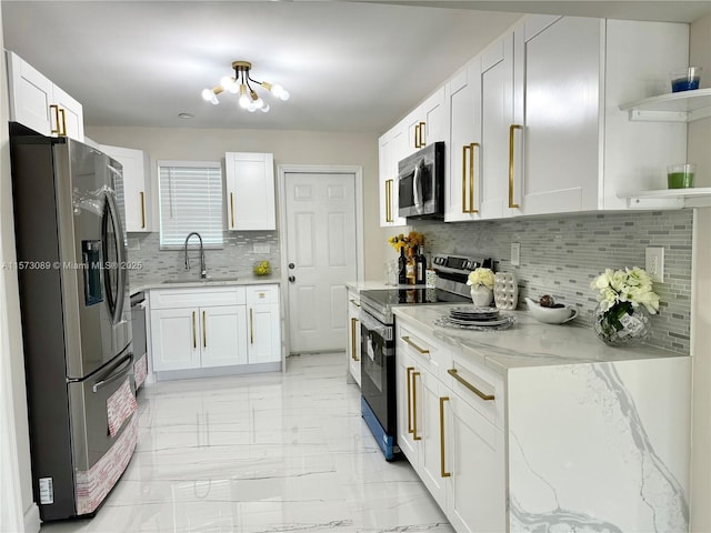 kitchen with sink, backsplash, white cabinets, light stone countertops, and stainless steel appliances