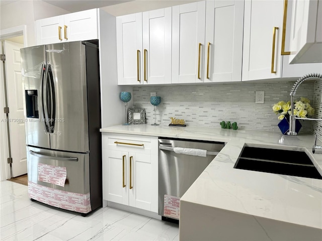 kitchen featuring decorative backsplash, light stone counters, white cabinets, and stainless steel appliances