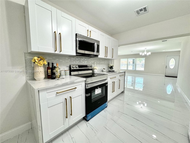 kitchen featuring light stone countertops, white cabinetry, appliances with stainless steel finishes, and tasteful backsplash