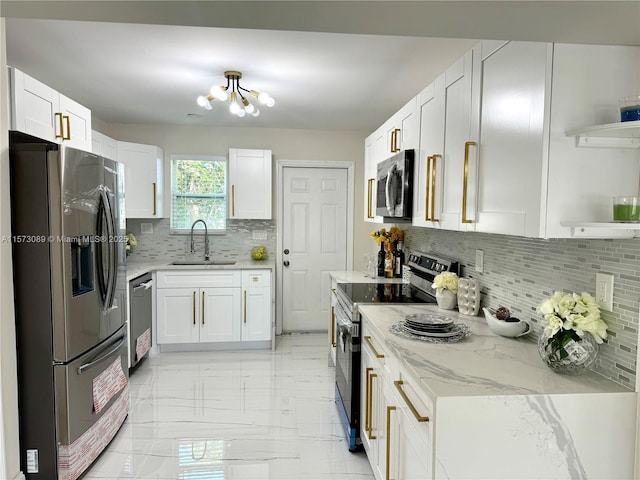 kitchen featuring sink, light stone counters, white cabinets, and stainless steel appliances