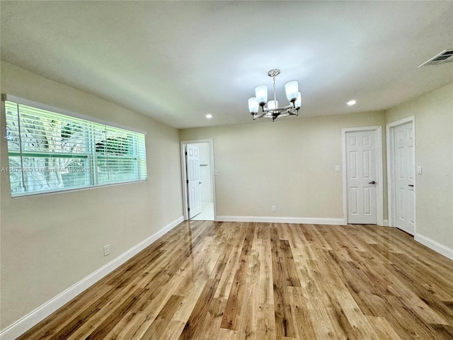 unfurnished dining area featuring light hardwood / wood-style floors and an inviting chandelier