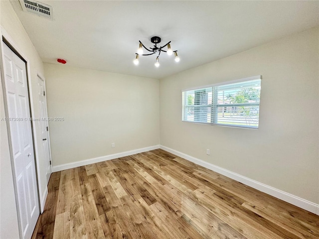 interior space featuring light hardwood / wood-style floors and an inviting chandelier