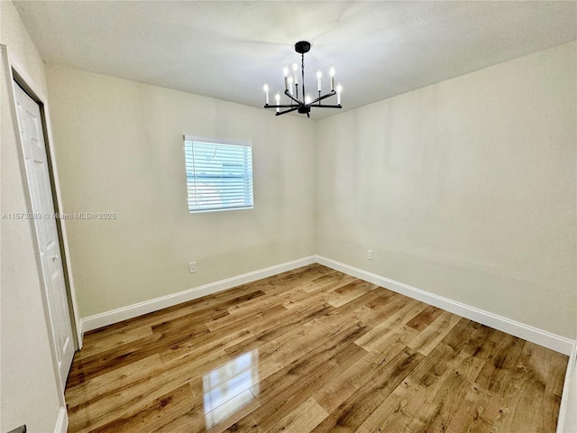 unfurnished dining area with hardwood / wood-style flooring and a chandelier