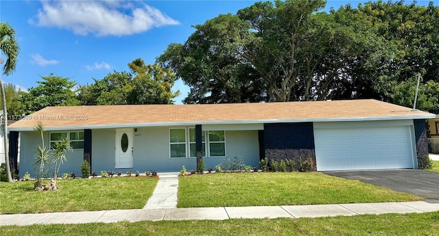 single story home featuring a garage and a front lawn