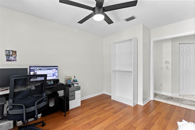 office with light hardwood / wood-style flooring, ceiling fan, and a textured ceiling