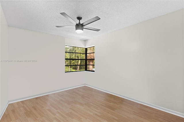 empty room featuring a textured ceiling, ceiling fan, and light wood-type flooring