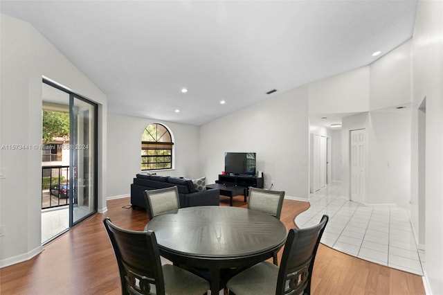 dining area featuring lofted ceiling and light tile floors