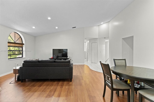 living room with light hardwood / wood-style flooring and high vaulted ceiling