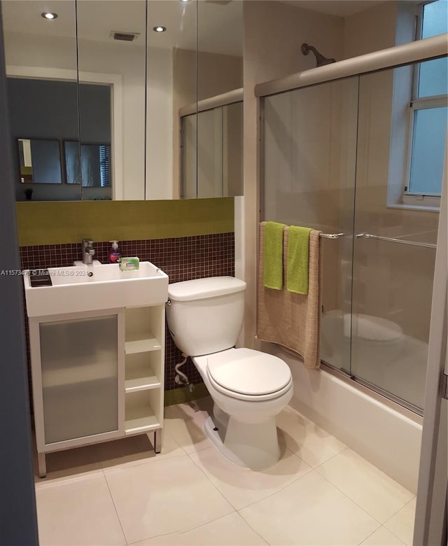 bathroom with tile flooring, combined bath / shower with glass door, tasteful backsplash, and toilet