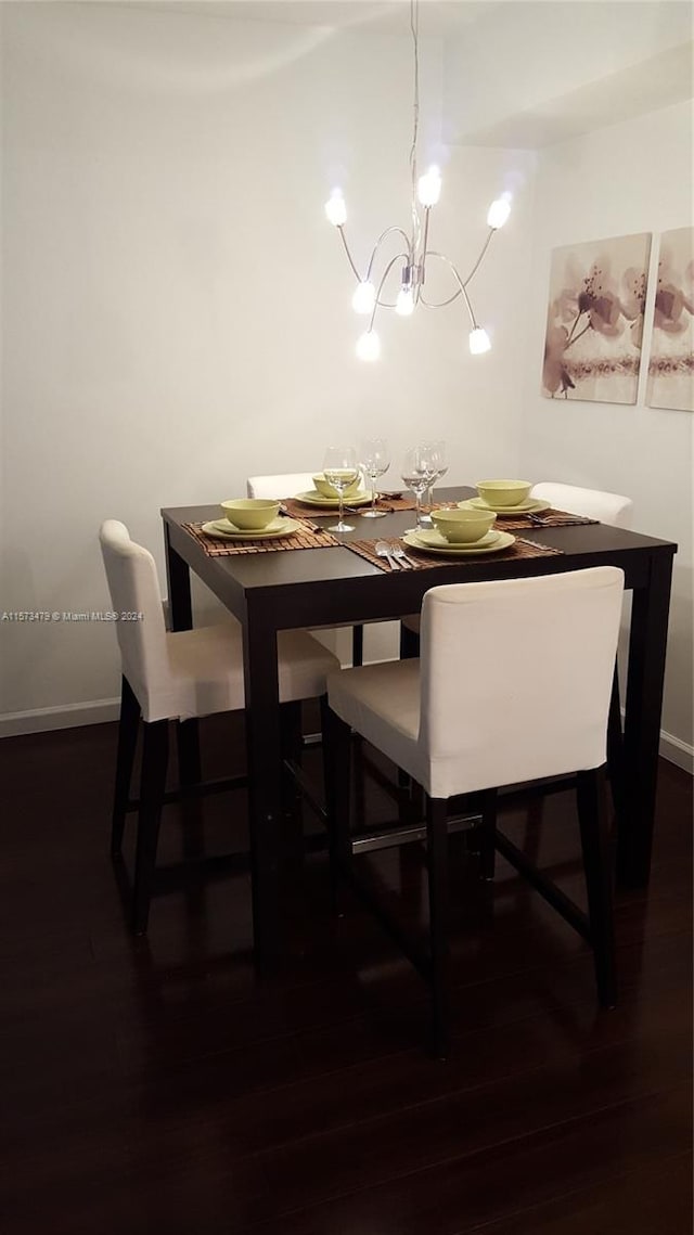 dining area featuring a chandelier and dark wood-type flooring