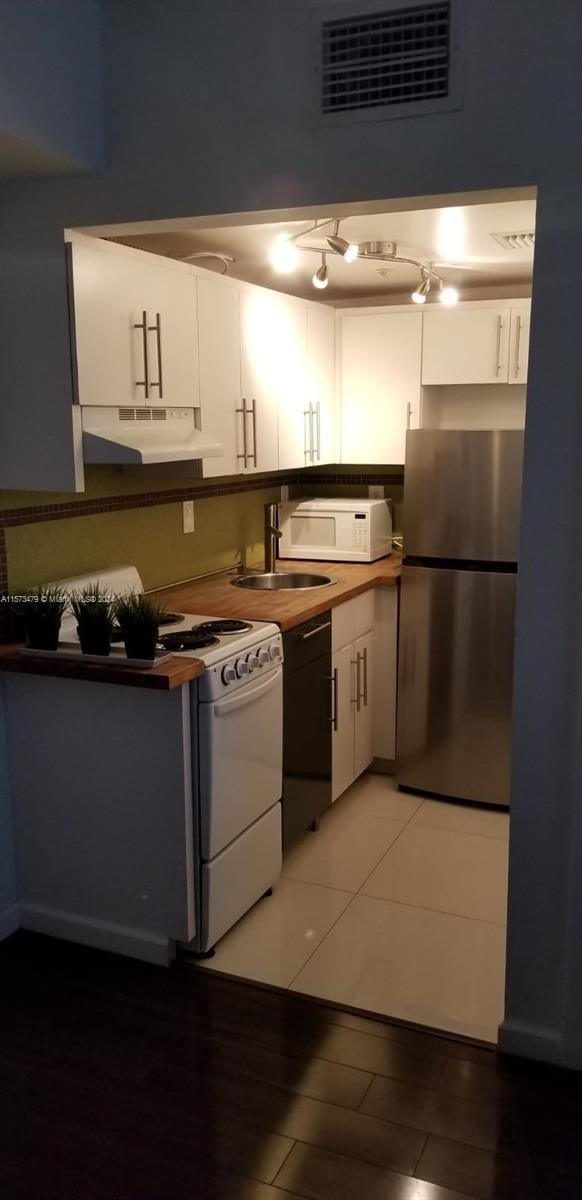 kitchen with white cabinets, white appliances, and sink