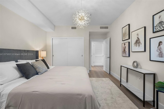 bedroom featuring a closet, a chandelier, and dark hardwood / wood-style floors