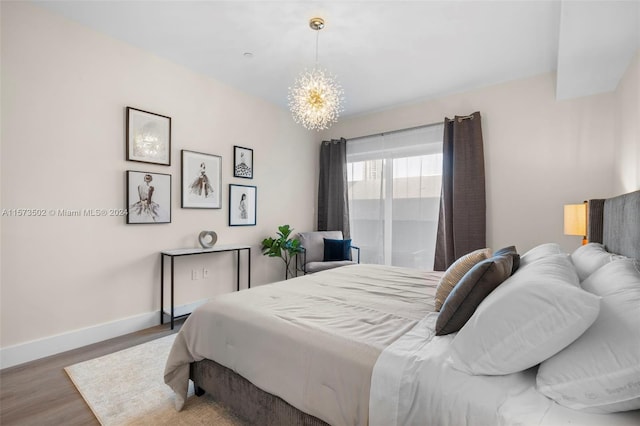 bedroom with a notable chandelier and dark hardwood / wood-style floors