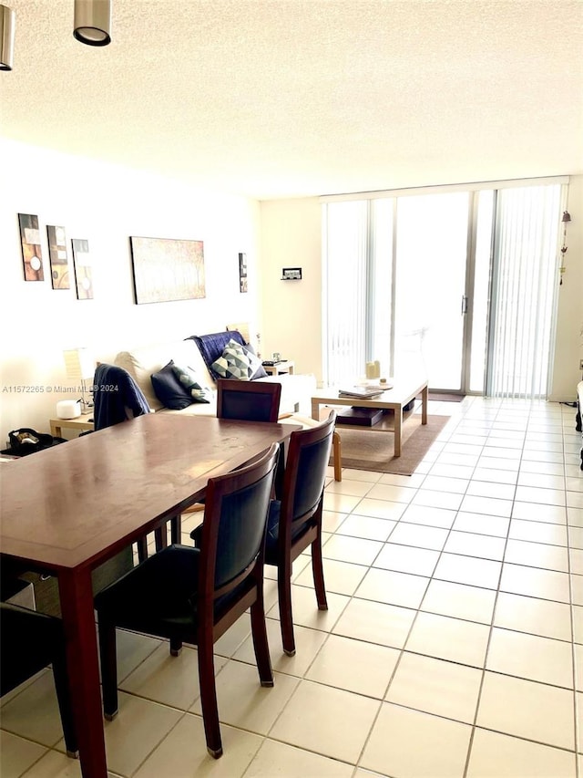 dining space with a textured ceiling and tile floors