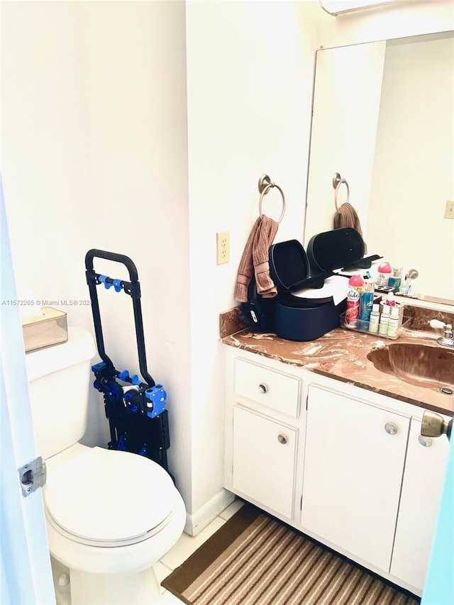 bathroom featuring vanity, tile floors, and toilet