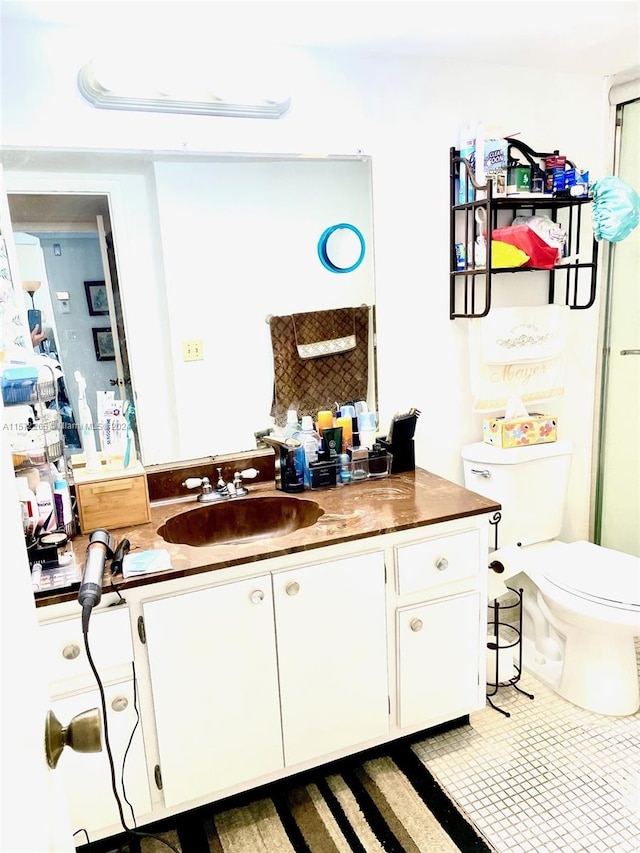 bathroom featuring vanity with extensive cabinet space and toilet