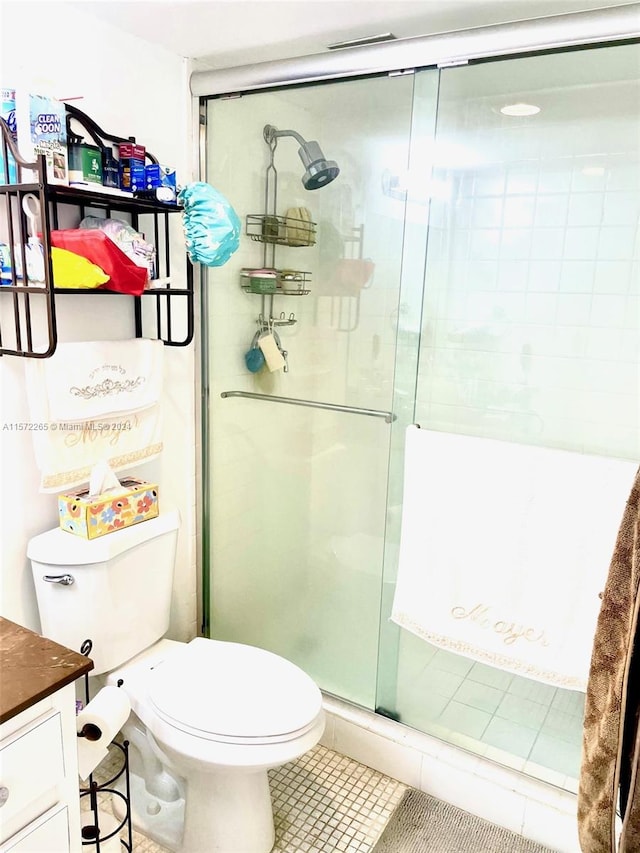 bathroom featuring an enclosed shower, toilet, tile flooring, and vanity