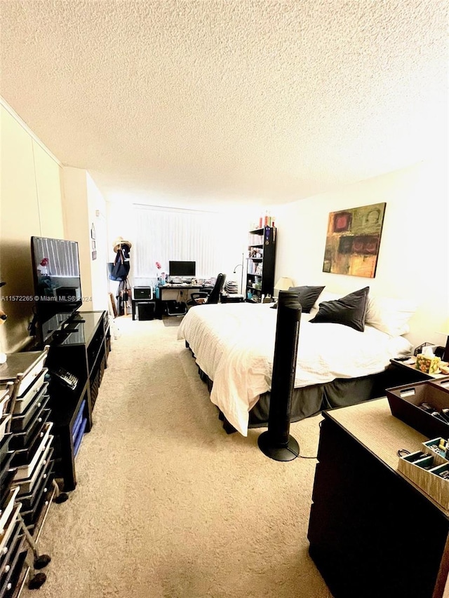 bedroom with light colored carpet and a textured ceiling