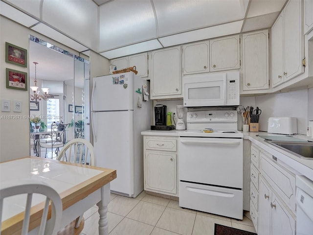 kitchen with white appliances, white cabinetry, a chandelier, sink, and light tile floors