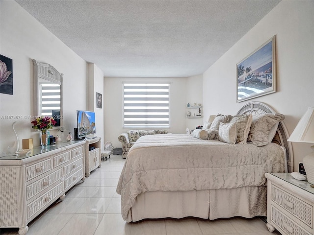 bedroom featuring a textured ceiling and light tile flooring