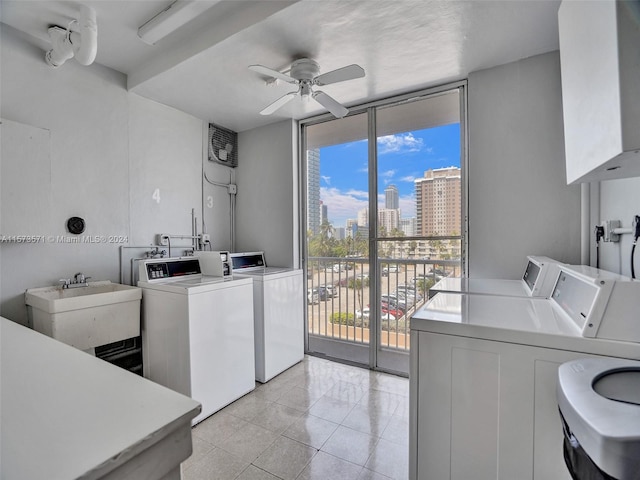 washroom with sink, ceiling fan, light tile floors, and washing machine and clothes dryer