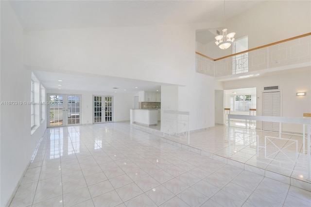 tiled empty room with a high ceiling and a notable chandelier