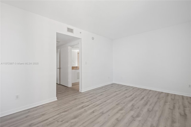 spare room with light wood-style flooring and baseboards