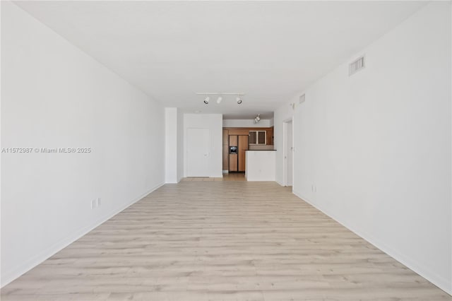 spare room with light wood-style floors, rail lighting, and visible vents