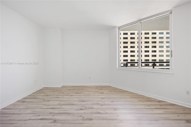 empty room with wood finished floors and baseboards