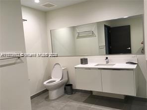 bathroom featuring vanity, toilet, and tile flooring